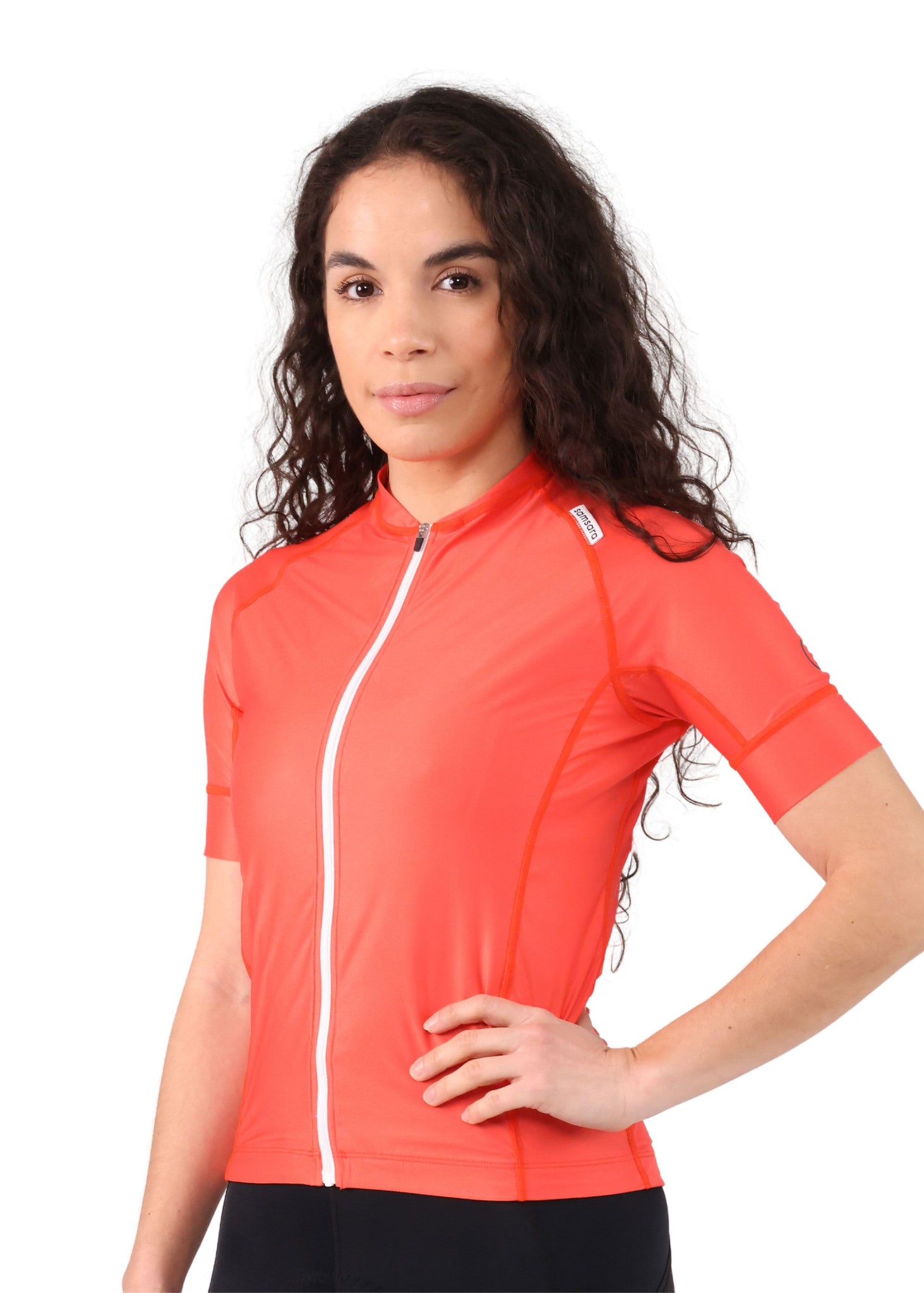 Close-up side view, from the waist up, of a woman wearing a red poppy cycling jersey.