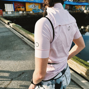 Woman outdoors wearing Samara Magnolia cycle shorts and Cherry Blossom jersey and vest.